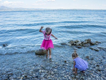 Søsken leker sammen på stranda