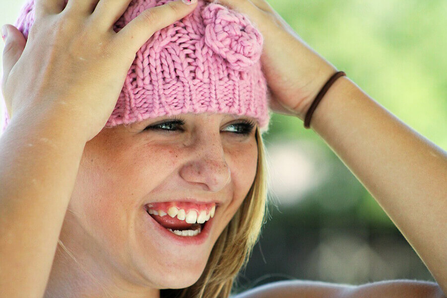Jente med rosa lue, smiler