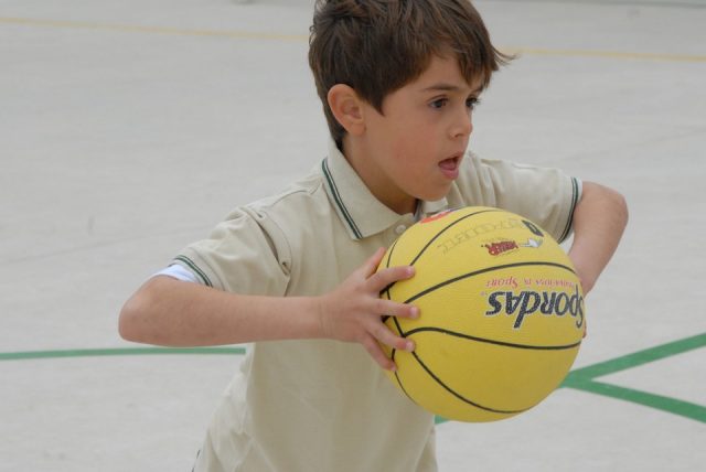 Gutt har ballen i basketballkamp